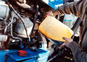 man adding fluid to tractor