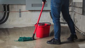 man mopping basement floor