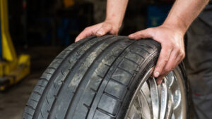 man rolling tire on floor
