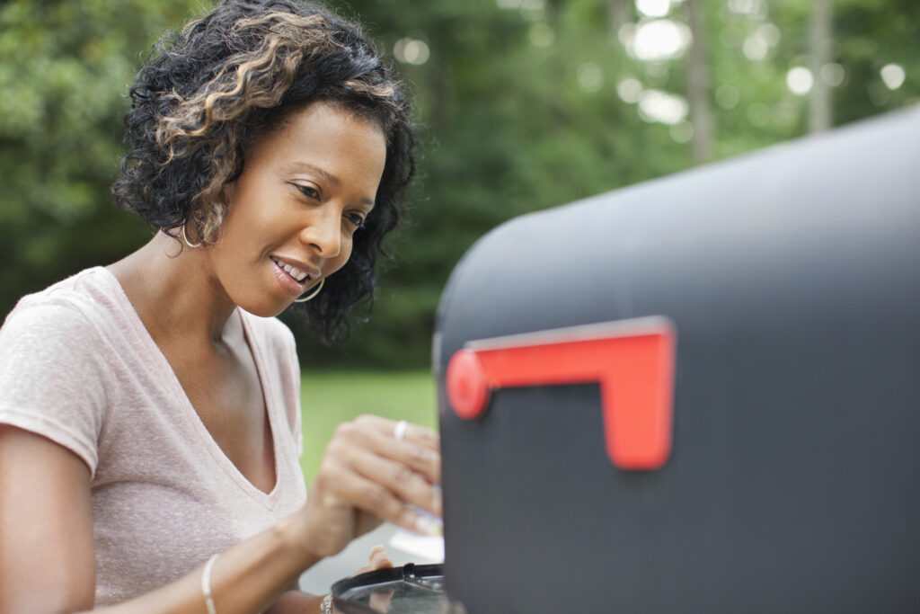 woman grabbing mail out of mailbox
