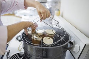 woman taking jars out of water bath canner
