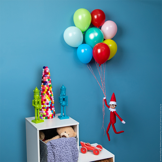 elf holding onto balloons