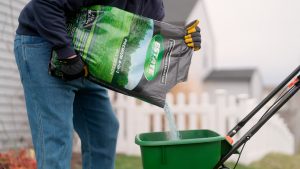 man pouring estate 4-in-1 fertilizer