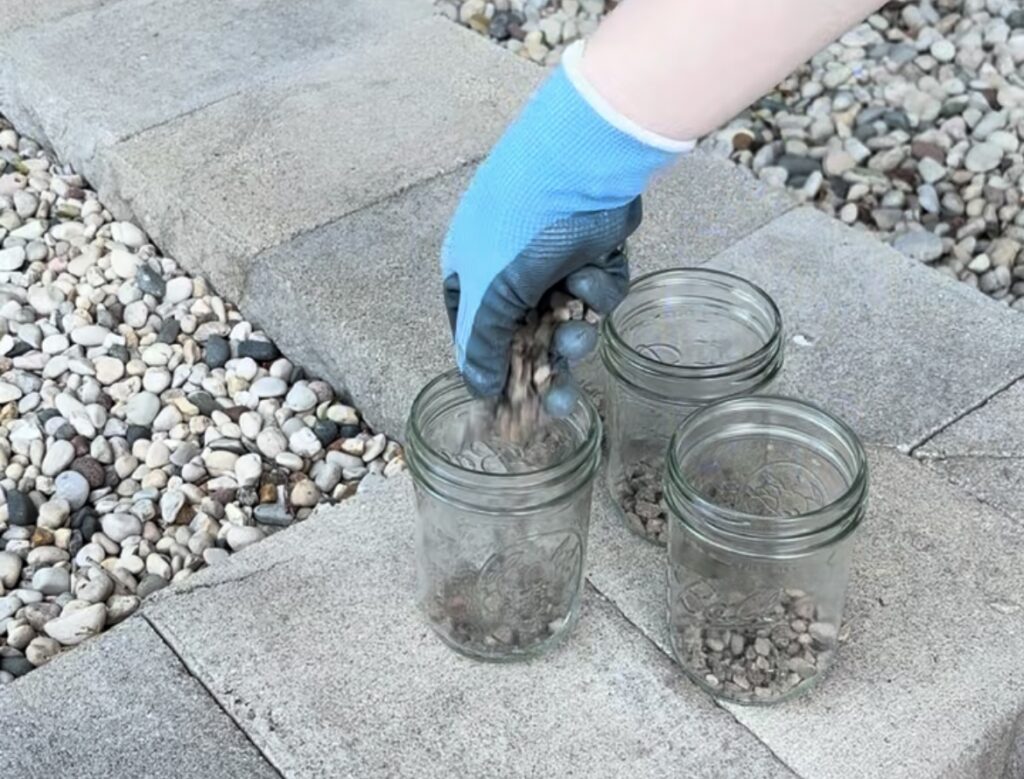 adding pebbles to mason jars