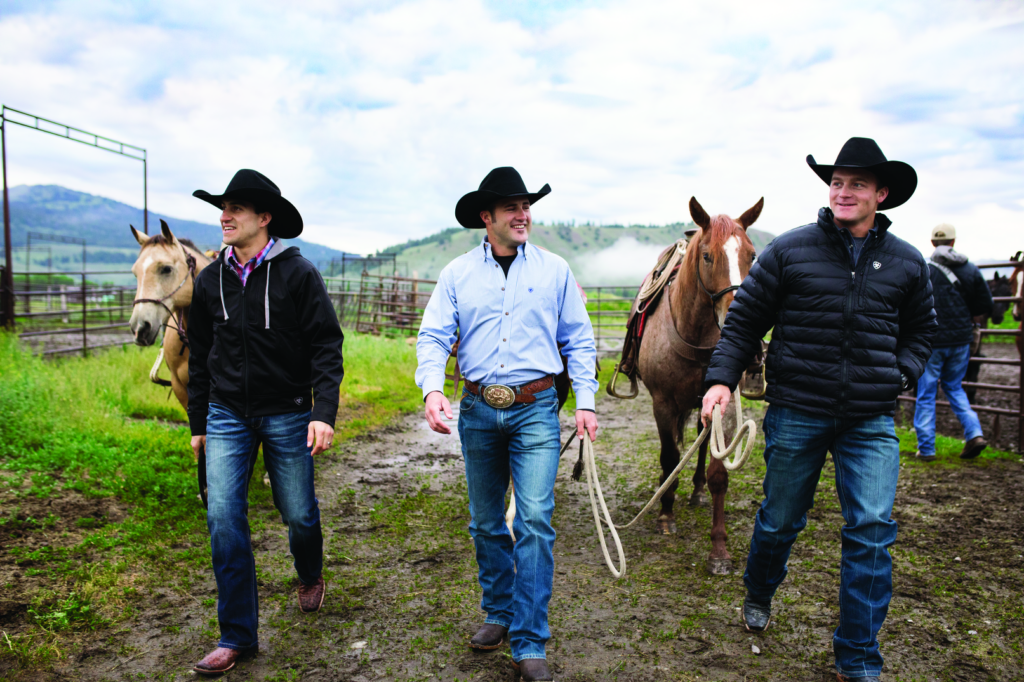 three men walking with horses