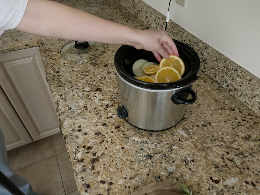 adding orange slices to slow cooker
