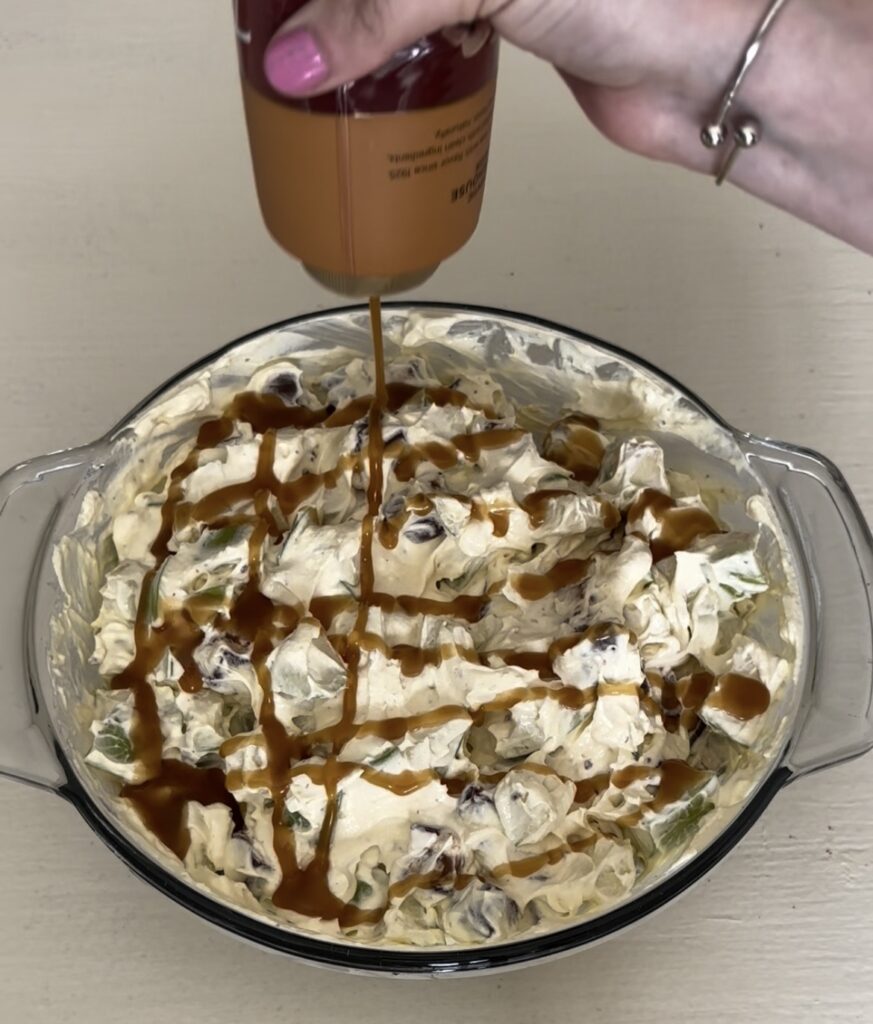 drizzling caramel sauce on top of Snickers salad