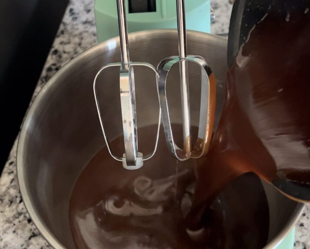 adding mixture to standing mixer