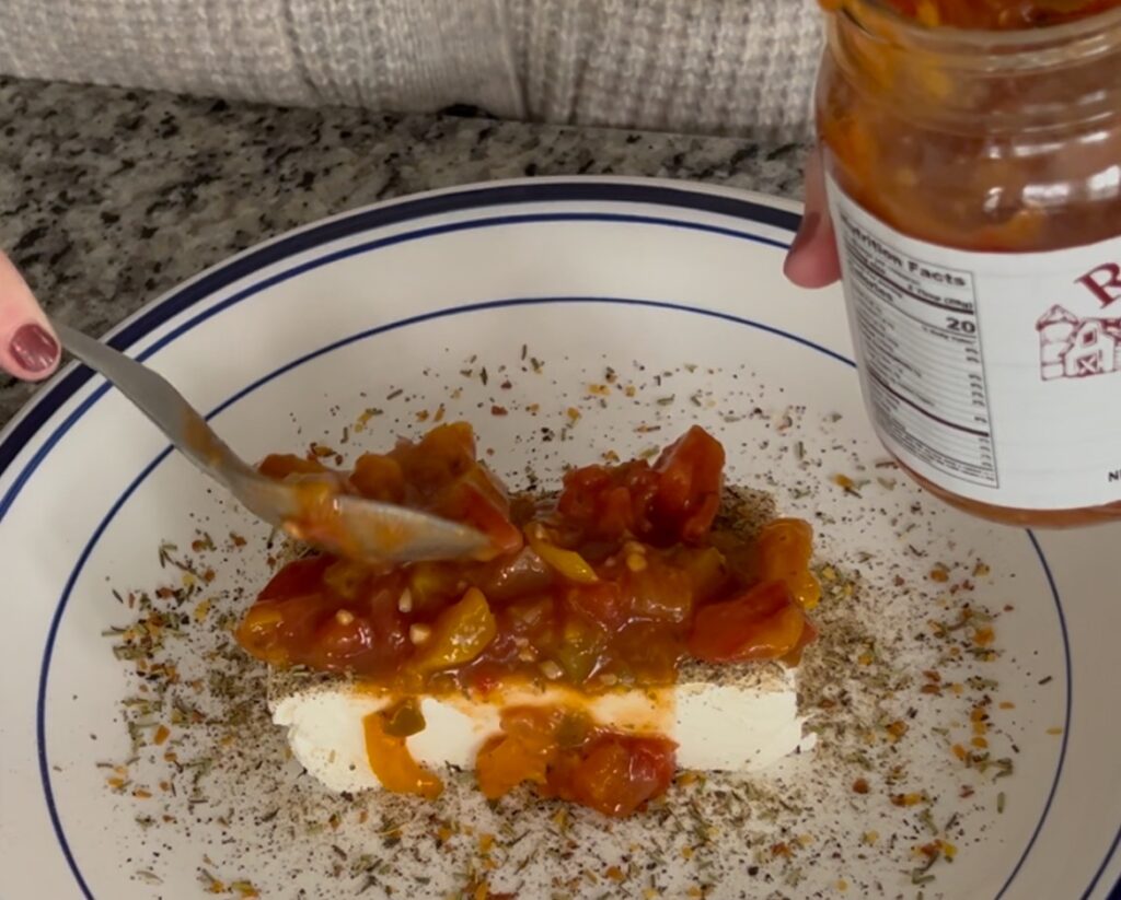 spooning salsa on cream cheese