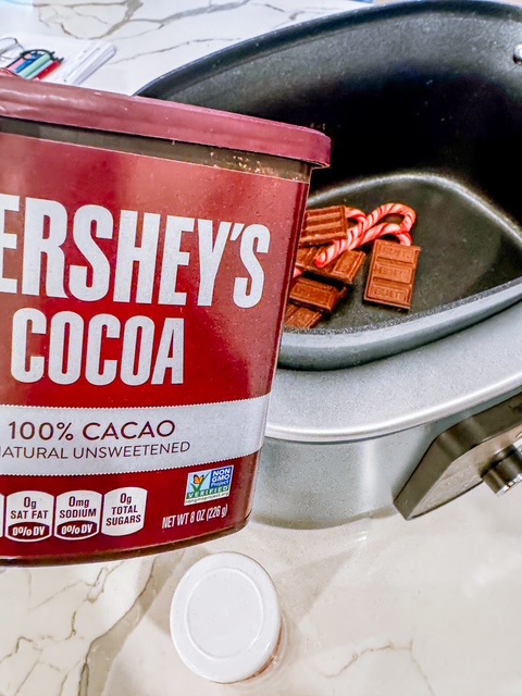 adding chocolate bars, candy canes, and cocoa powder to slow cooker