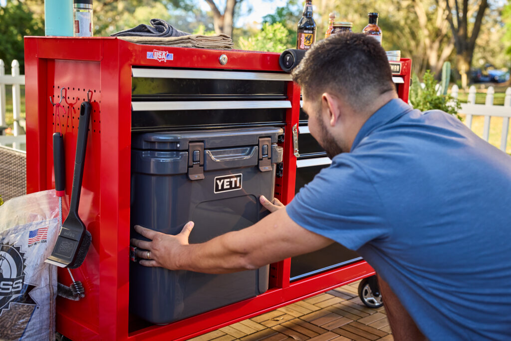 man putting cooler in tool chest