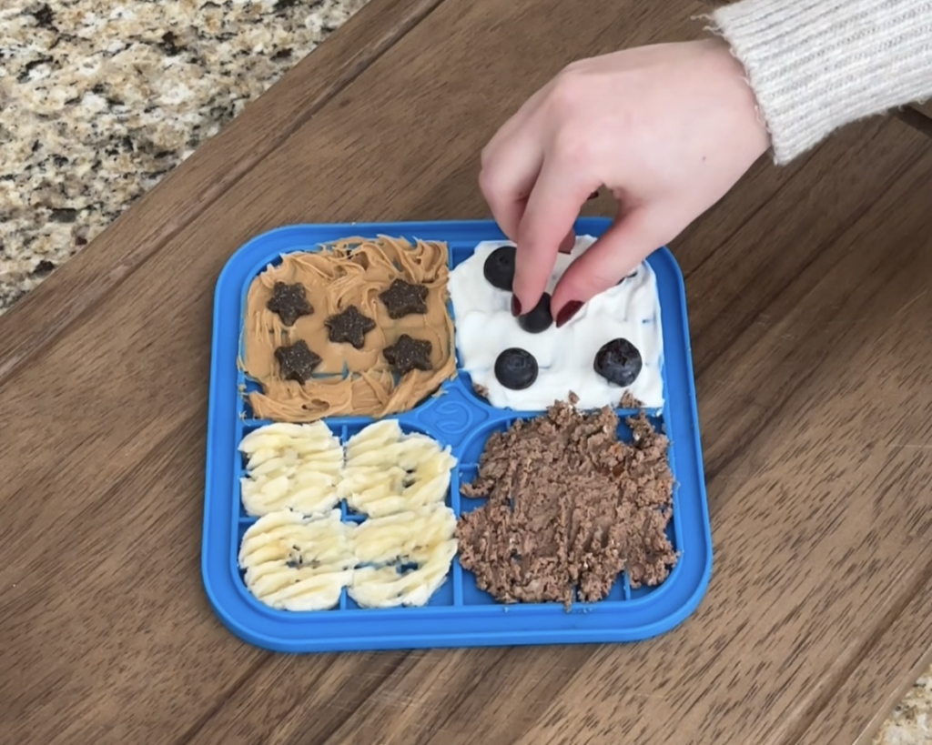 adding treats and blueberries to lick mat