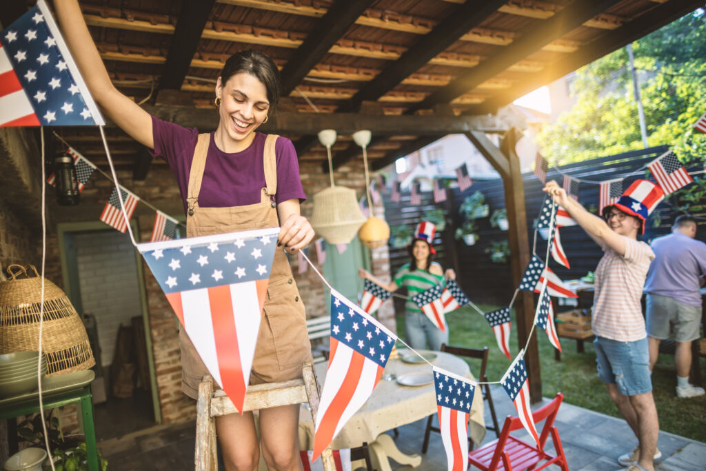 man and woman hanging up American flag banner