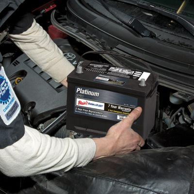 person installing an auto battery